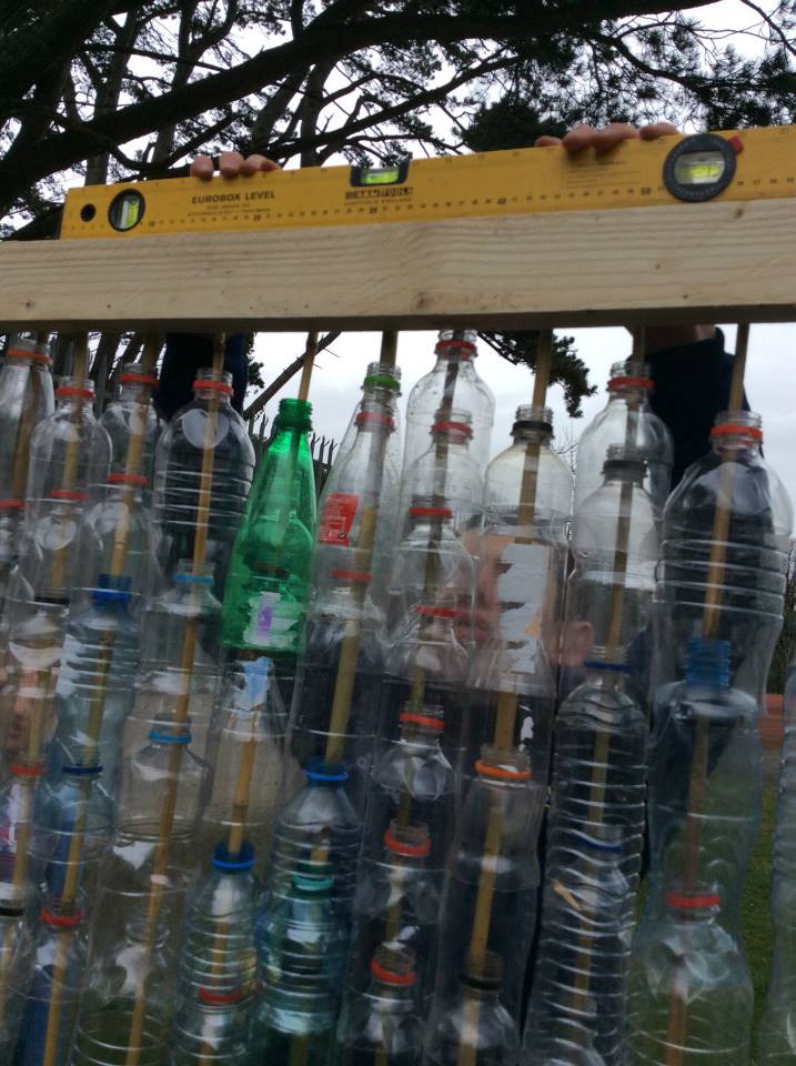 A close up of plastic bottles being used as walls for the greenhouse